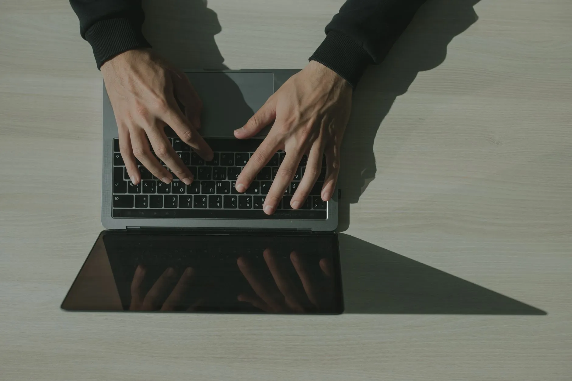 Dłonie piszące na laptopie widzianym z góry