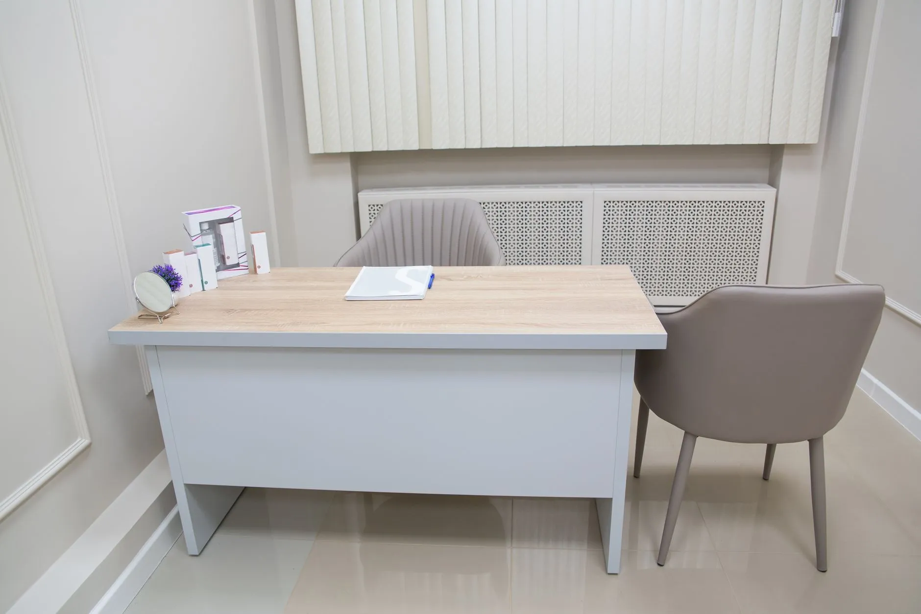 Jasne wnętrze gabinetu medycznego z biurkiem i dwoma krzesłami