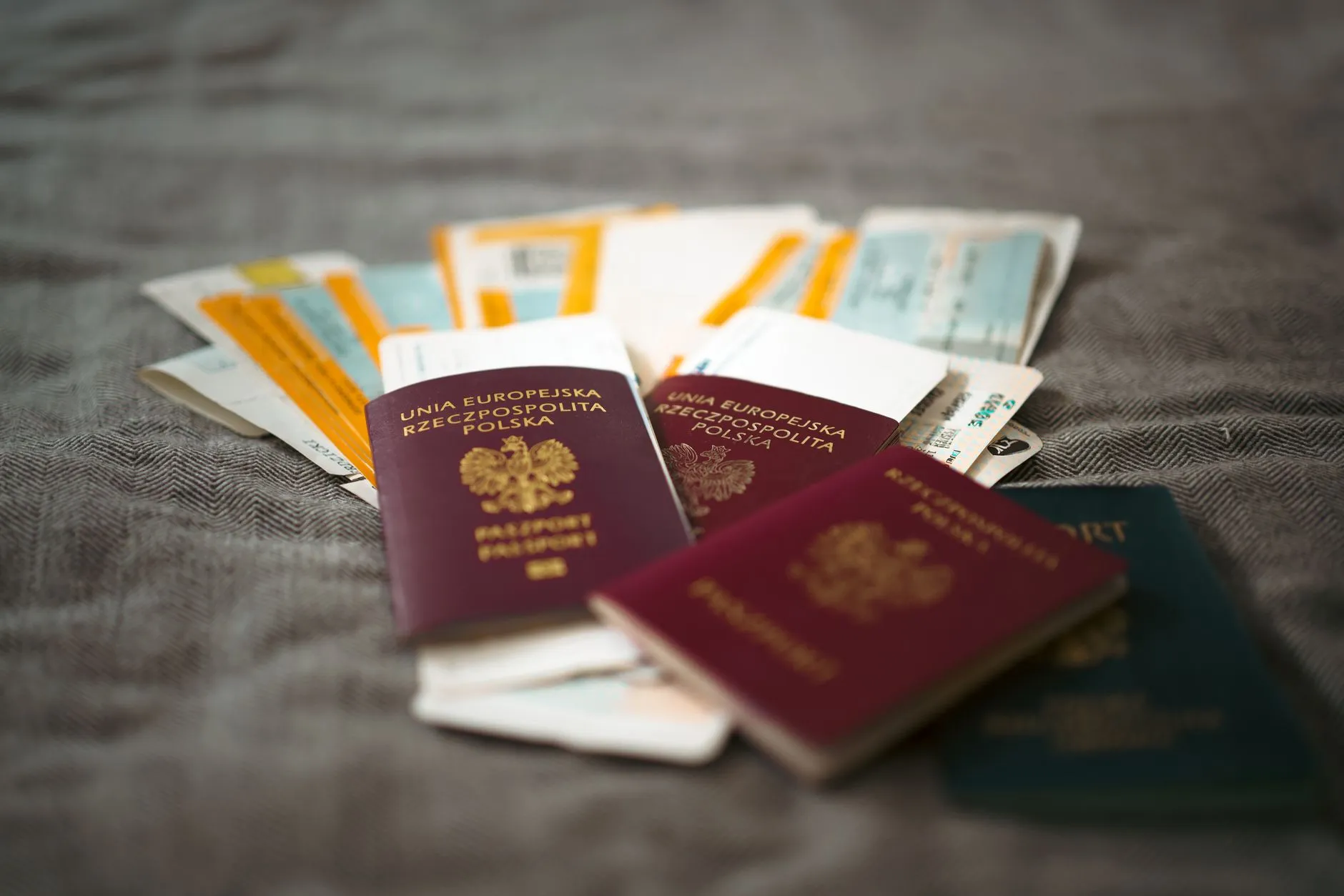 Polskie paszporty i bilety lotnicze na szarej tkaninie
