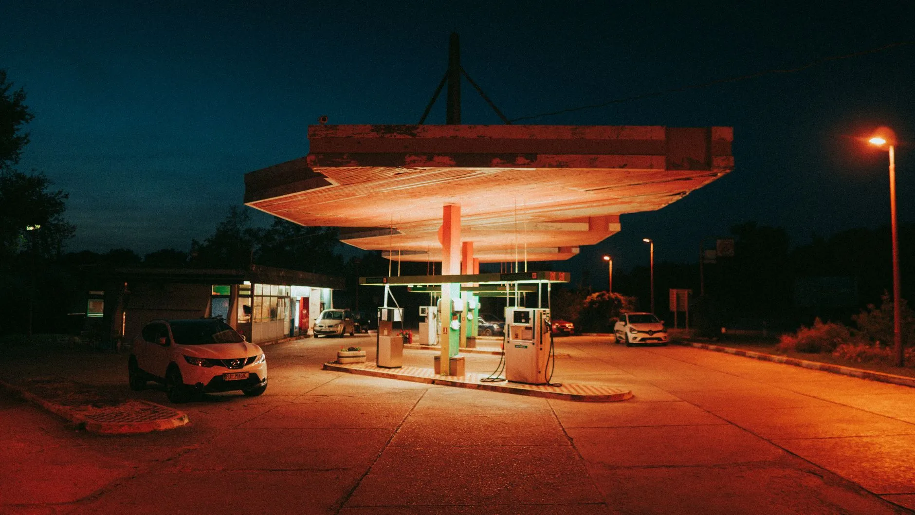 Nocna stacja paliw oświetlona pomarańczowymi lampami
