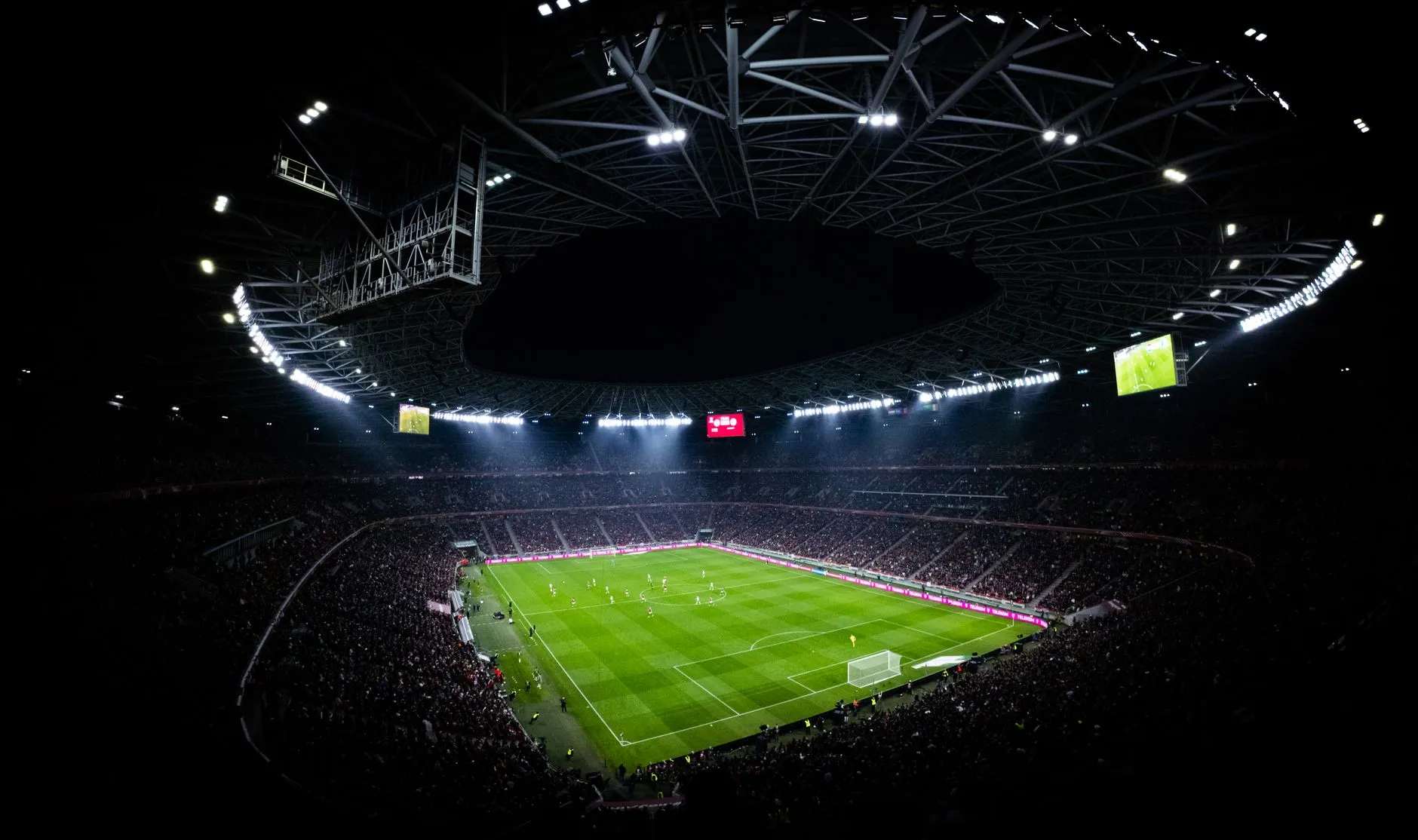 Nocny mecz piłkarski na oświetlonym stadionie pełnym kibiców