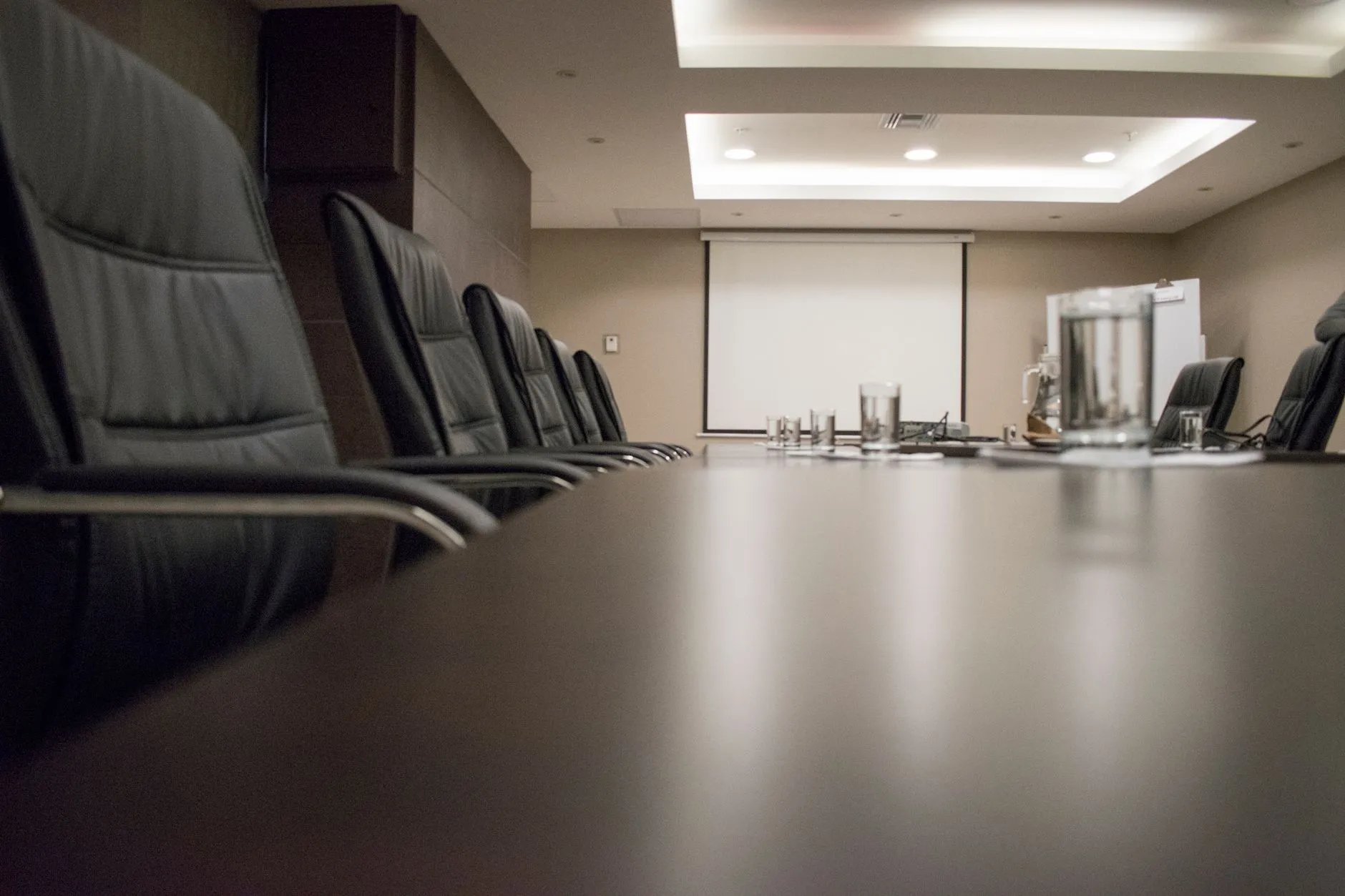 Pusta sala konferencyjna z czarnymi krzesłami i stołem