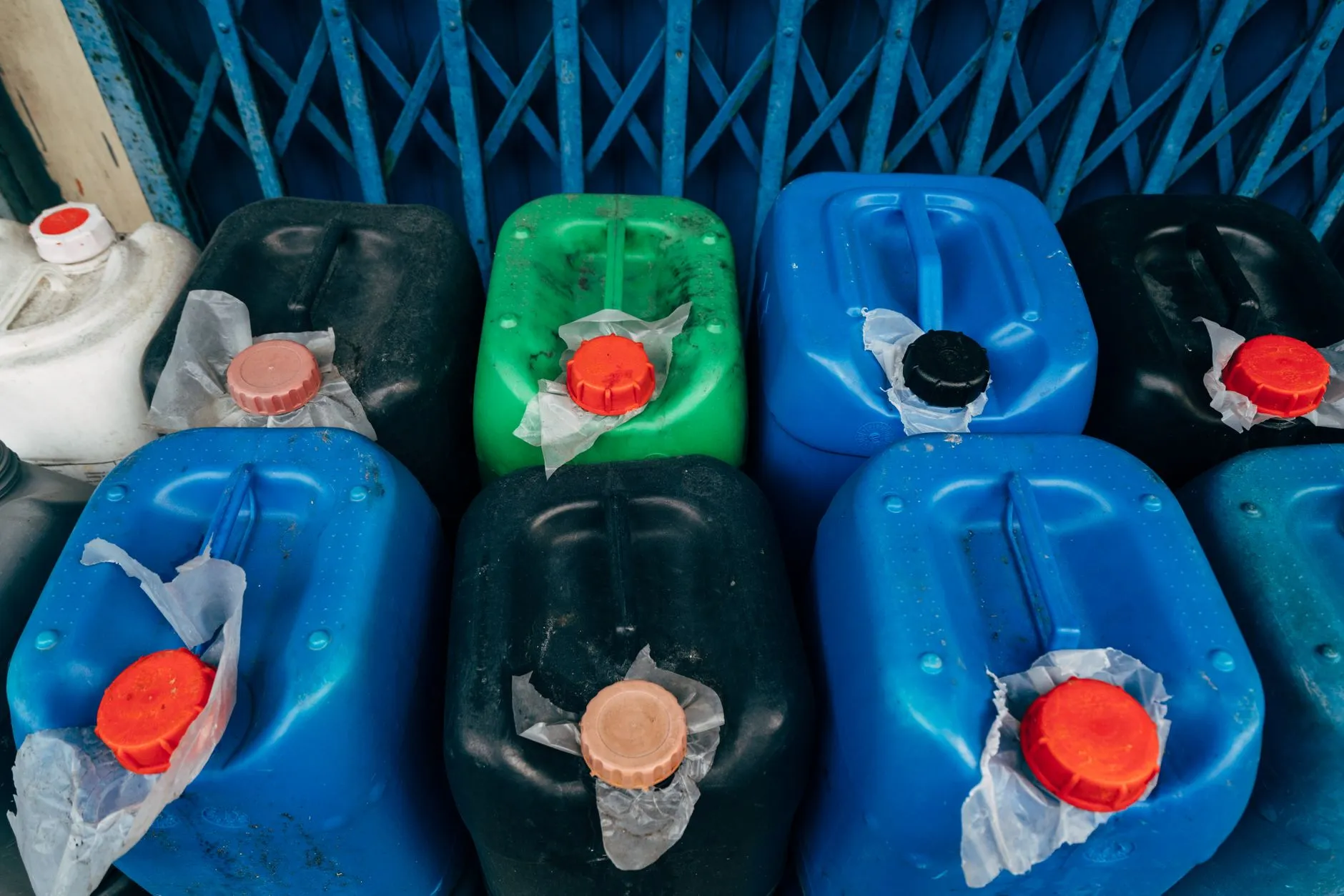 Kolorowe plastikowe kanistry z czerwonymi zakrętkami