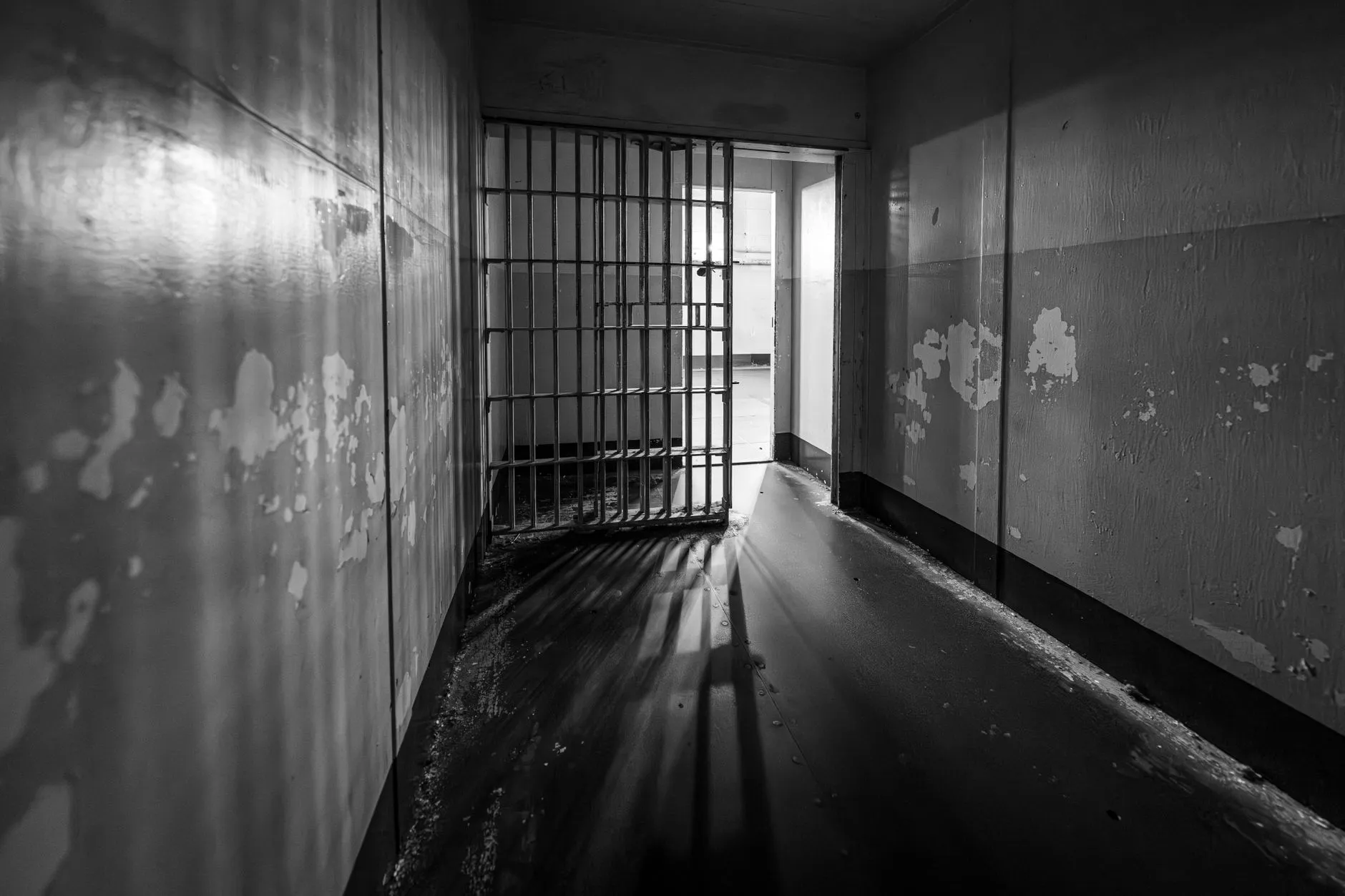 Korytarz więzienny z otwartą kratą i światłem