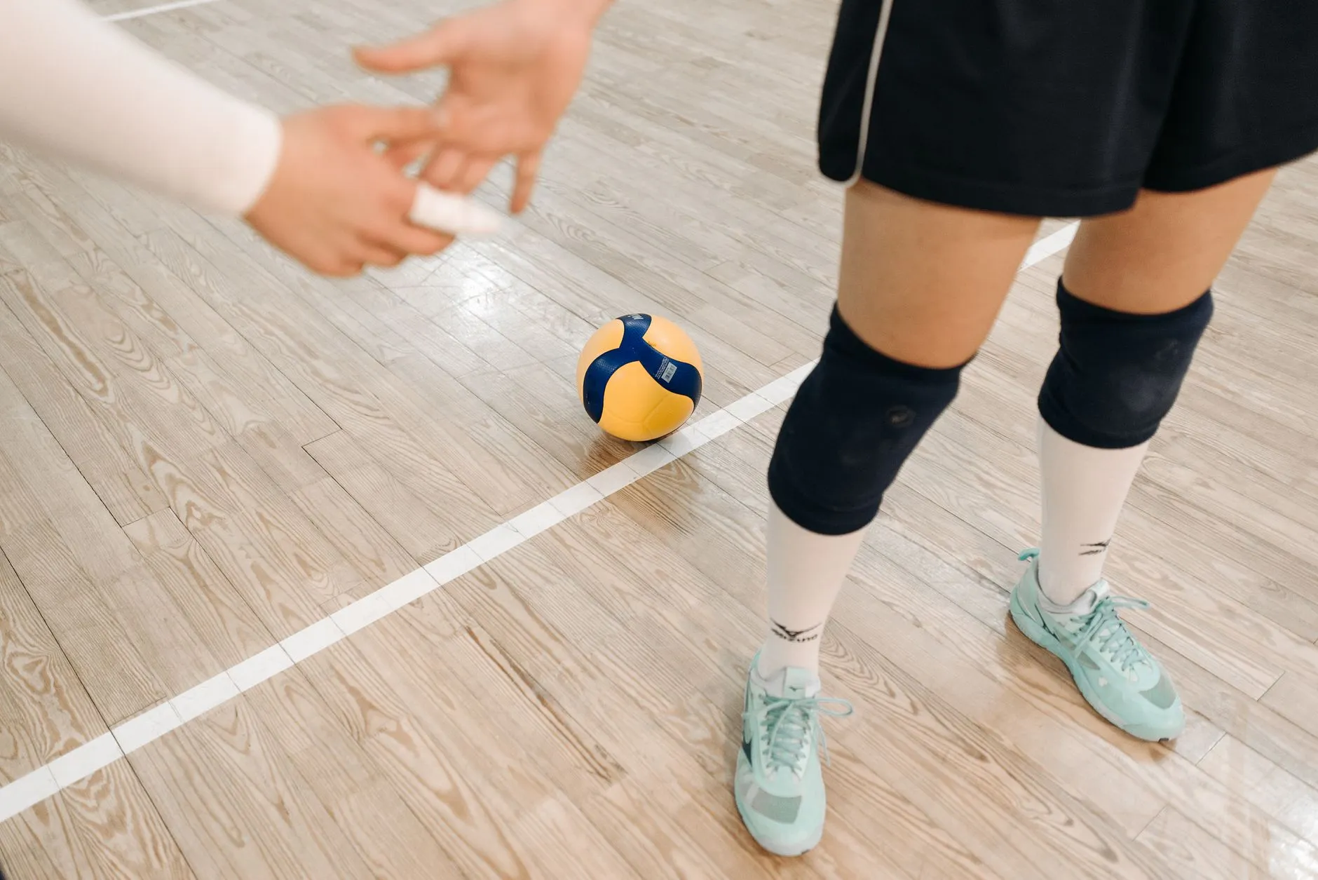 Piłka siatkowa i zawodniczki na hali sportowej
