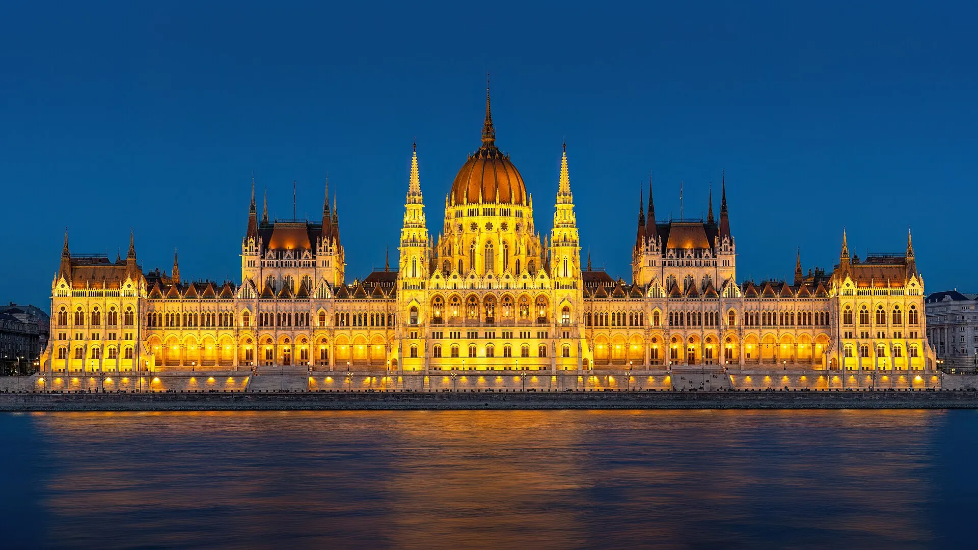 Gmach parlamentu w Budapeszcie nad Dunajem o zmierzchu w 2023 roku