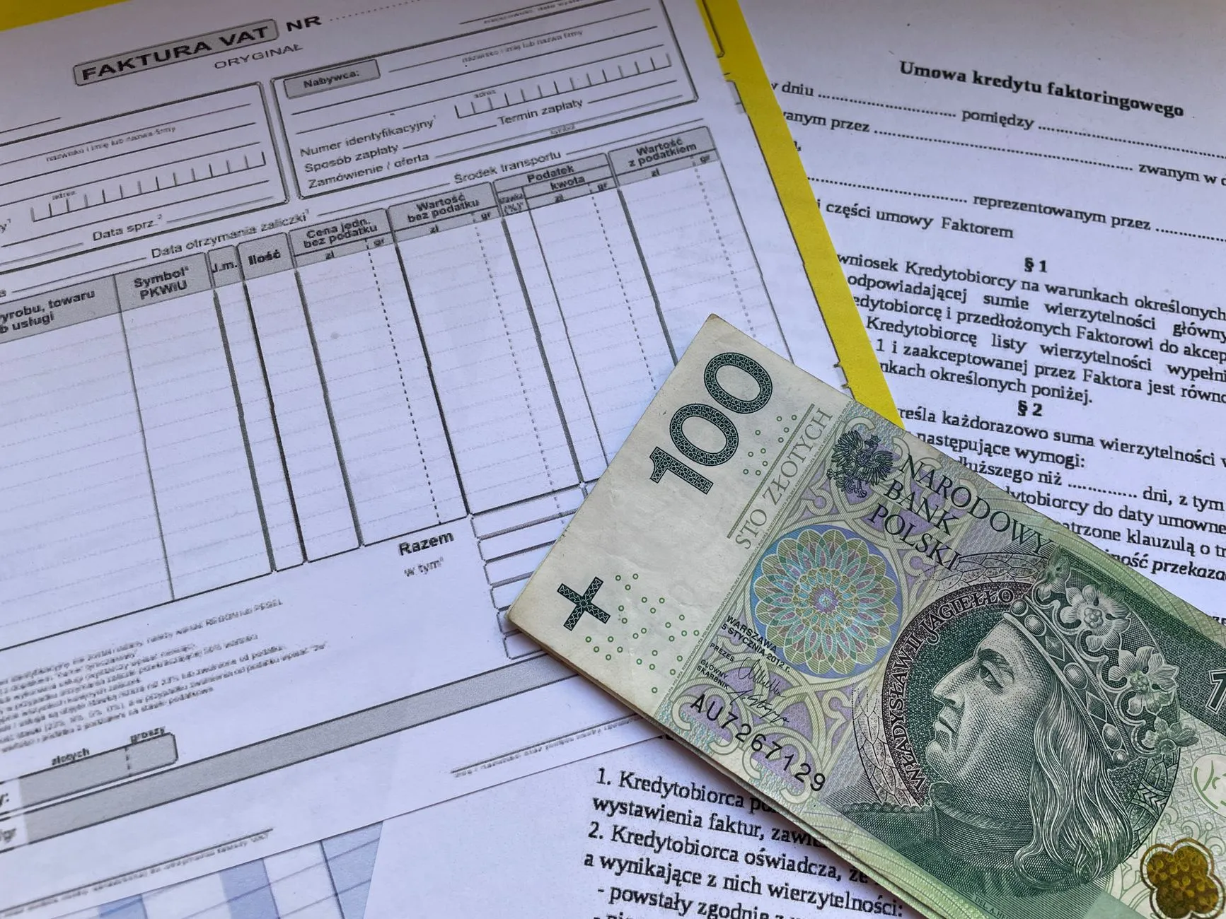 Banknot stu złotych na polskich fakturach i dokumentach finansowych
